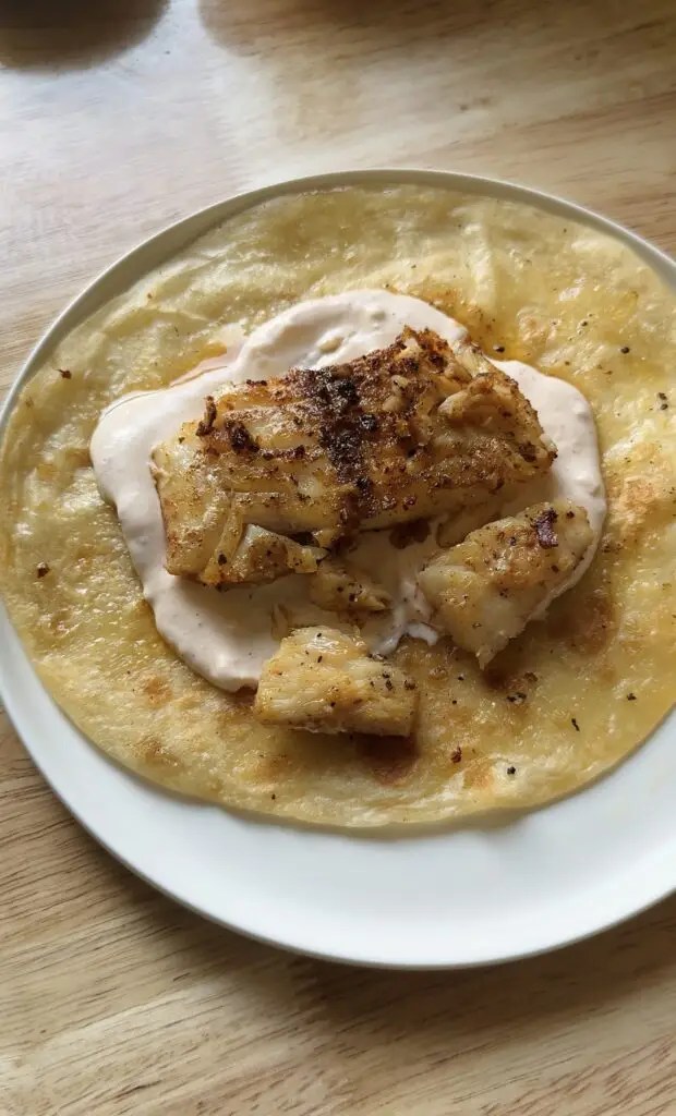 tortilla with sauce and fish on top