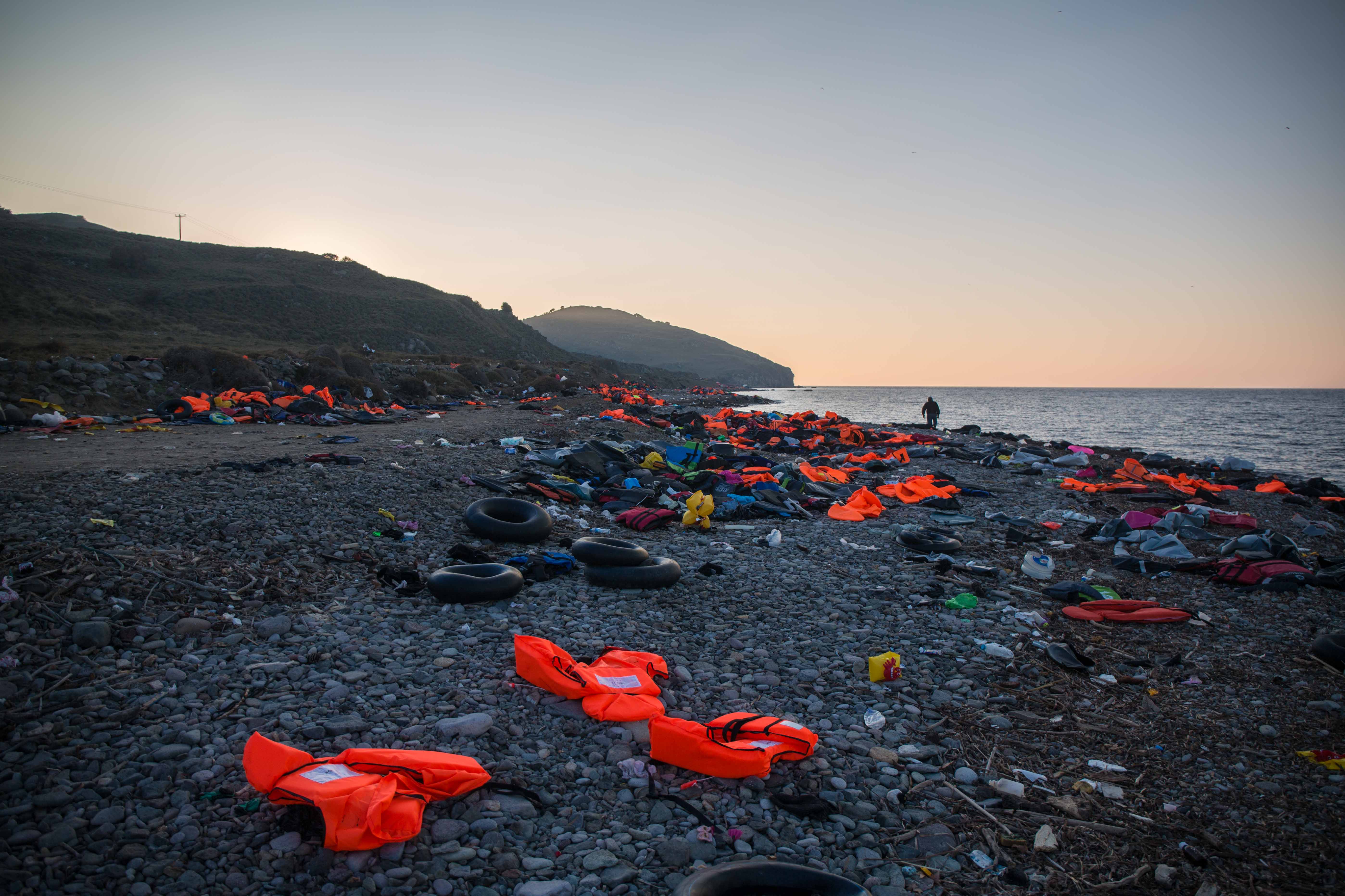 Scouring the shore strewn with life jackets
