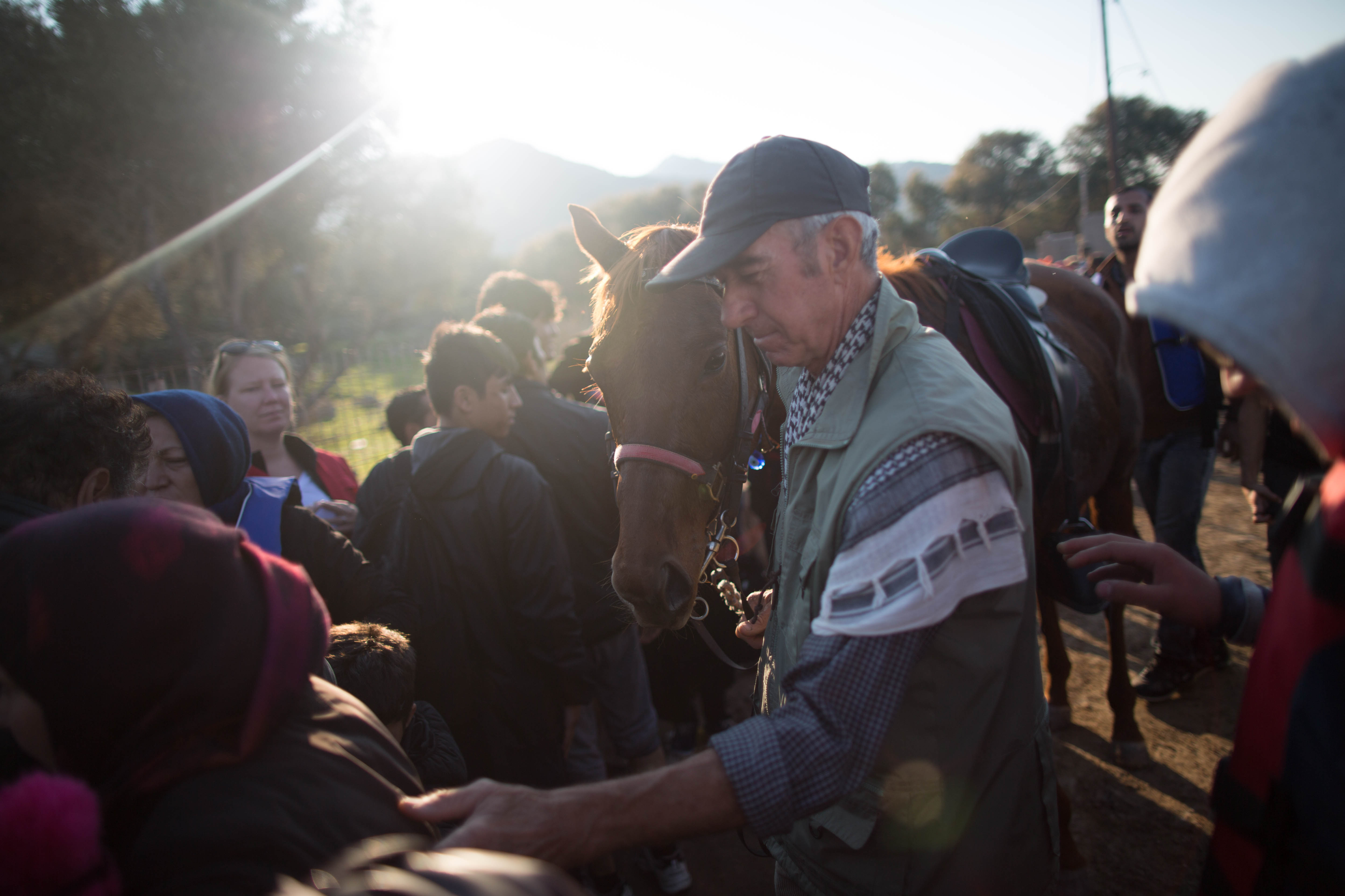 A local farmer makes his way through a crowd of freshly landed refugees on the 15km stretch of beach where 90% of the refugees land. Lesvos is an simple island covered olive trees, the staple of the economy, and monasteries.