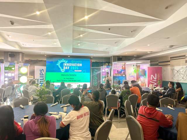 A presentation event at the Signify Innovation Day 2025 roadshow, featuring a speaker and an audience in a conference setting, with Philips and WiZ branding displayed in the background.