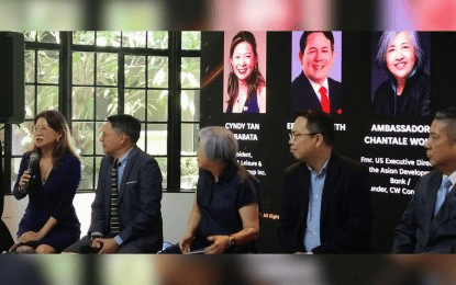 A panel discussion featuring diverse speakers, including Cindy Tan and Ambassador Chantale Wong, with a backdrop displaying their names and titles. The setting includes a modern conference room with natural light.
