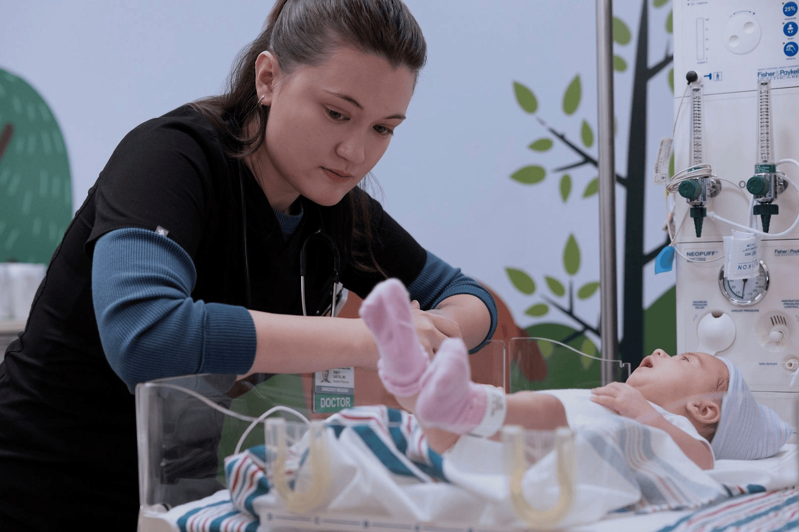 A nurse attending to a newborn baby in a hospital nursery, adjusting the baby's blanket and monitoring medical equipment.