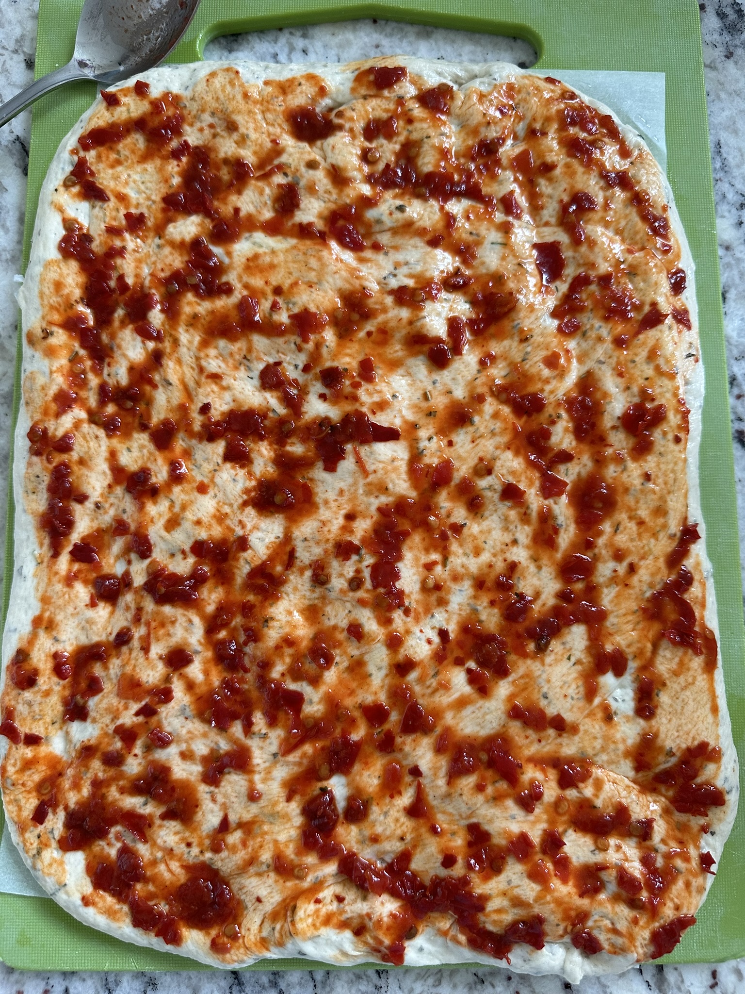 spread chilli paste on dough