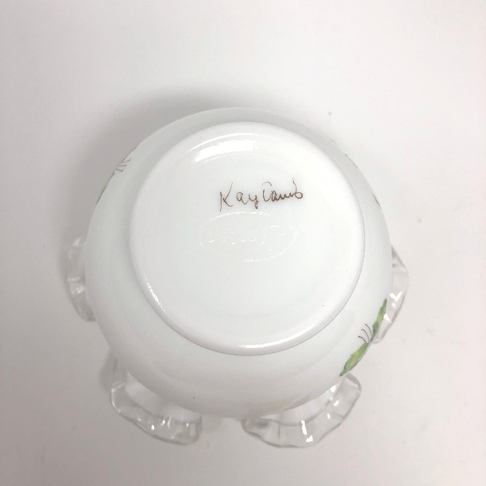 painted signature on the bottom of a white vase