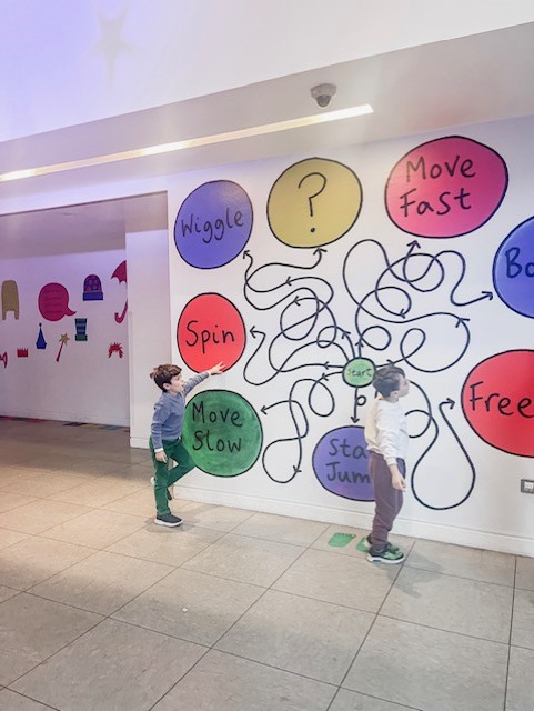 Two boys admire a wall mural in the Unicorn Theatre - one of the best theatres for kids in London