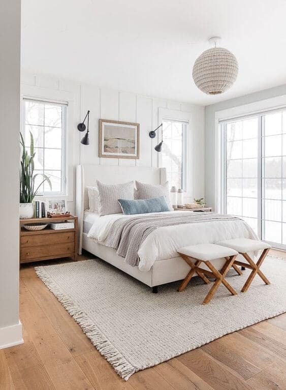 A couples' bedroom that uses cream, blue, and wood as its color palette.