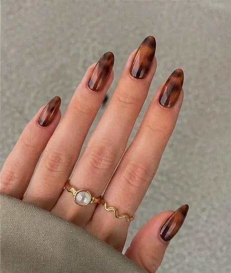 Glossy tortoiseshell almond nails in amber and brown tones for a classy fall manicure