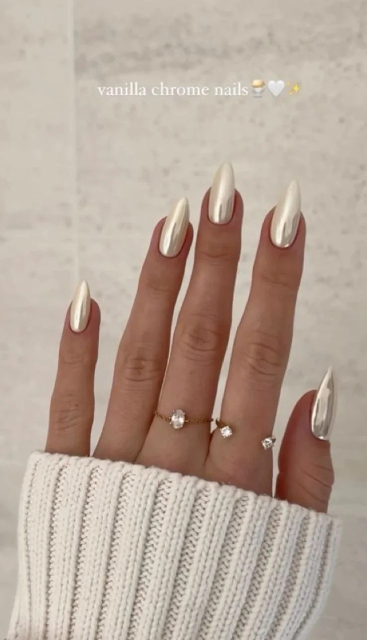 Creamy vanilla chrome almond nails with a glossy pearlescent finish