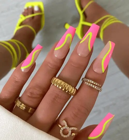 Neon pink and yellow irregular swirl french tip nails for summer. The perfect Miami nails