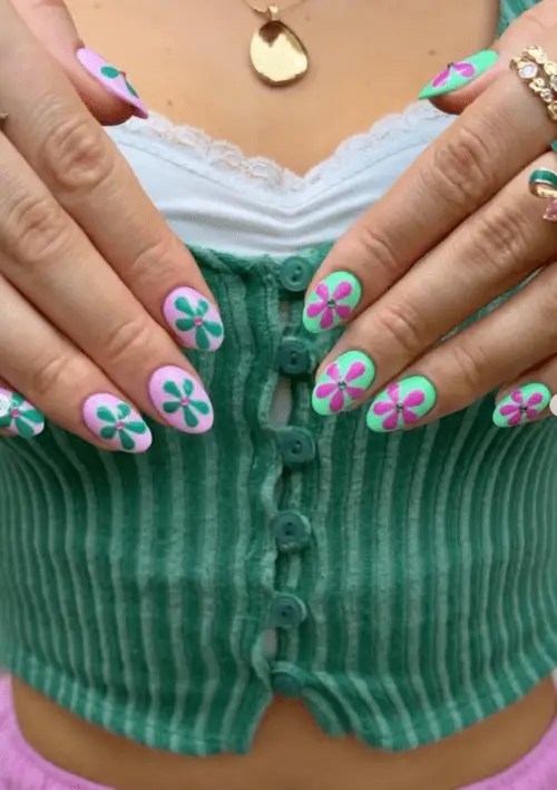Pink and green floral summer nails with flower designs and small gem accents, perfect for a soft and feminine 2025 manicure look.