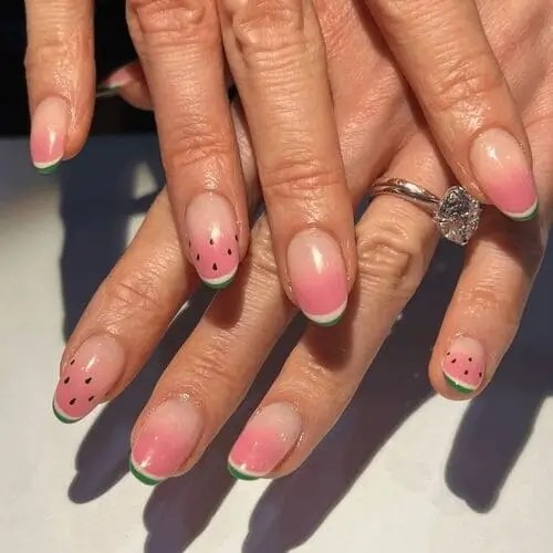 Watermelon nails with green french tips and accent nails with black seeds are a fruity and creative summer nail design