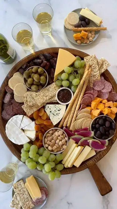 Create a snack board with crackers, cheeses, fruits, and meats for hosting a small party in your apartment