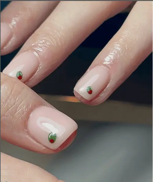 Minimalist nail design with tiny martini olives on a nude base, perfect for a classy, playful summer manicure look.