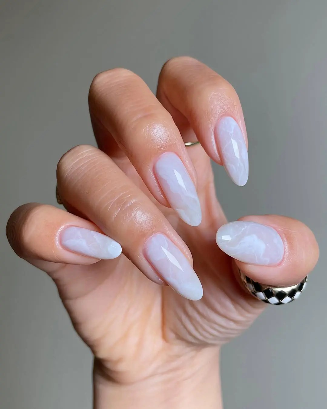 White quartz nails with milky translucent base and subtle marble swirls—elegant crystal-inspired summer nail design with a clean and ethereal vibe.
