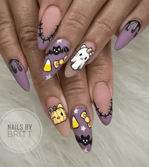 Hello Kitty Halloween nails with pastel purple base, candy corn, cartoon bats, stitched tips, and Sanrio-inspired nail art