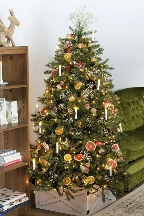 Romantic vintage Christmas tree decorated with dried citrus slices, roses, florals, and glowing lights for a cozy old-world holiday look.