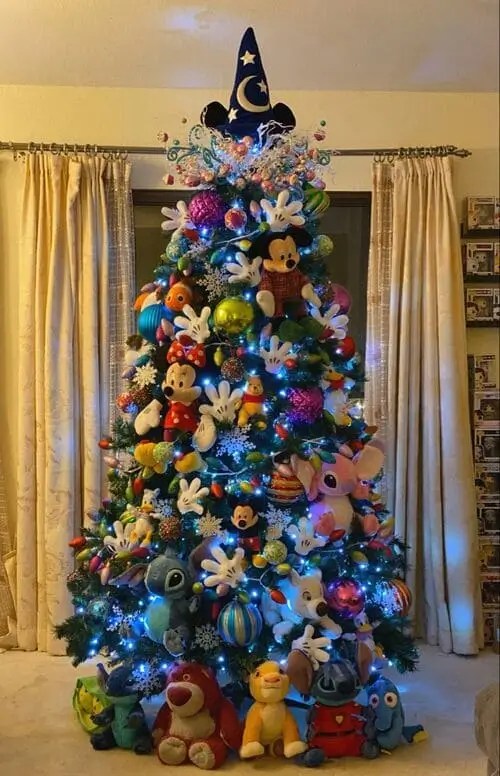 Disney Christmas tree theme decorated with Mickey, Stitch, Nemo plush toys, colorful ornaments, snowflakes, and Disney-inspired topper.