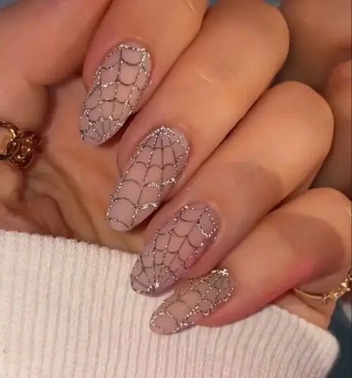 nude Halloween nails with glitter spiderweb nail art, chic sparkly spooky manicure design