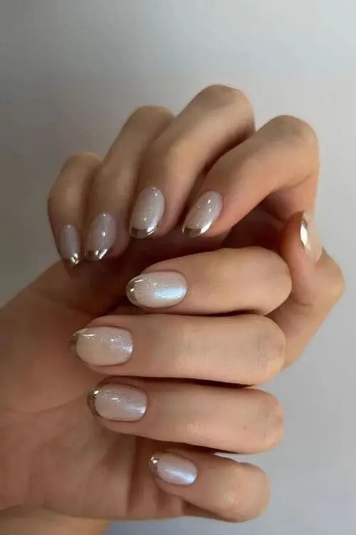 Frosted pearl nails with soft shimmer and silver chrome tips — elegant winter nail design for January with minimal, cozy aesthetic.