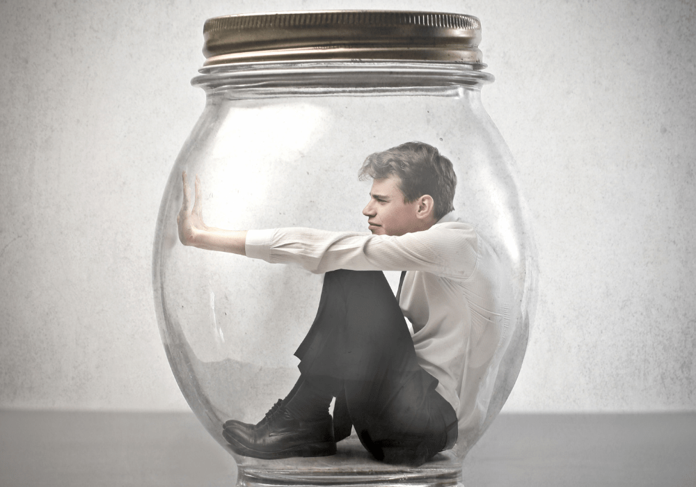 tutorial hell escape; A person in dress clothes is sitting inside of a clear glass jar with a gold lid.