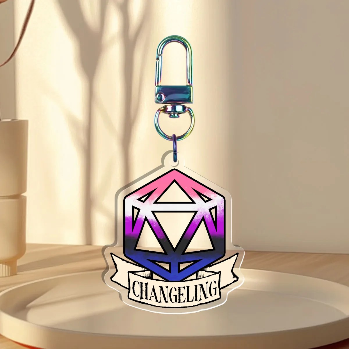Keychain Design – D20 die filled with gender fluid flag with a banner that states “changeling”, back is clear without iridescent holographic overlay