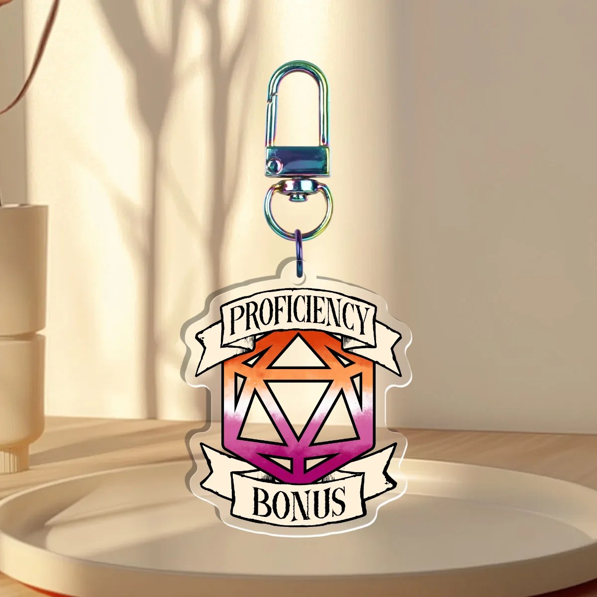 Keychain Design – D20 die filled with the lesbian flag with a banner that states “Proficiency Bonus”, back with is clear without iridescent holographic overlay