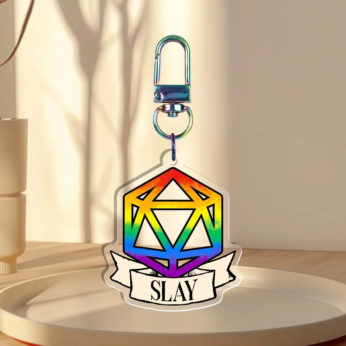 Keychain Design – D20 die filled with rainbow pride flag with a banner that states “slay”, back is clear without iridescent holographic overlay