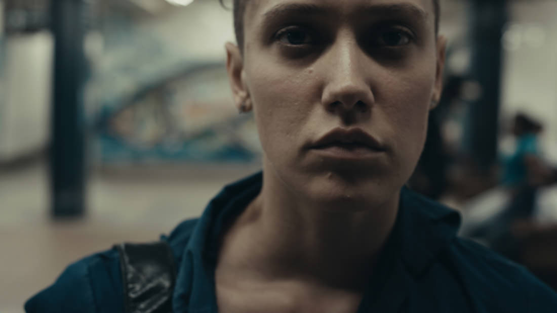 Close-up of a serious young woman with a blurred background.