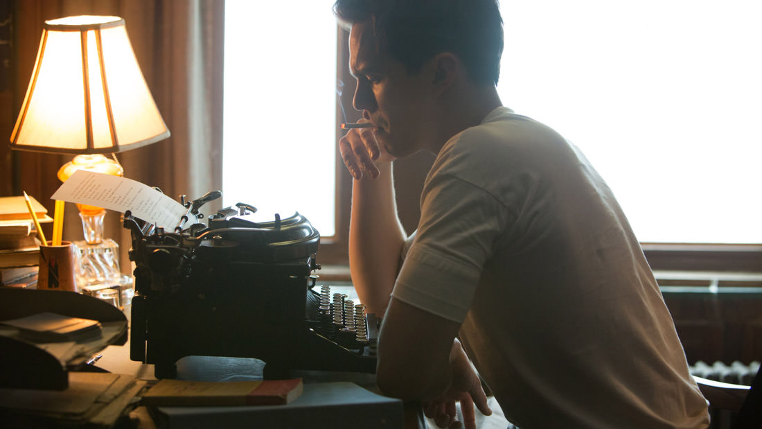 Person smoking while typing on a typewriter in soft light.