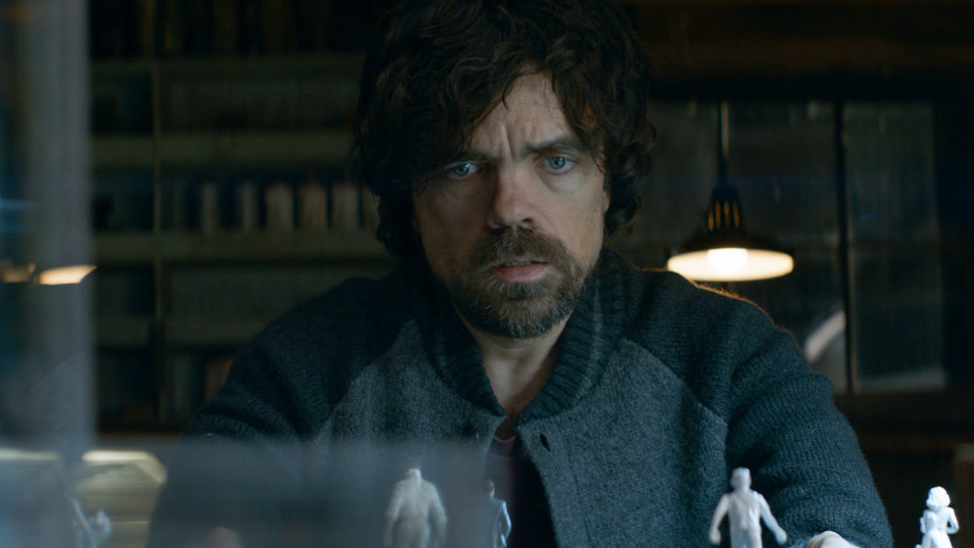 A man with curly hair and a beard staring intently.