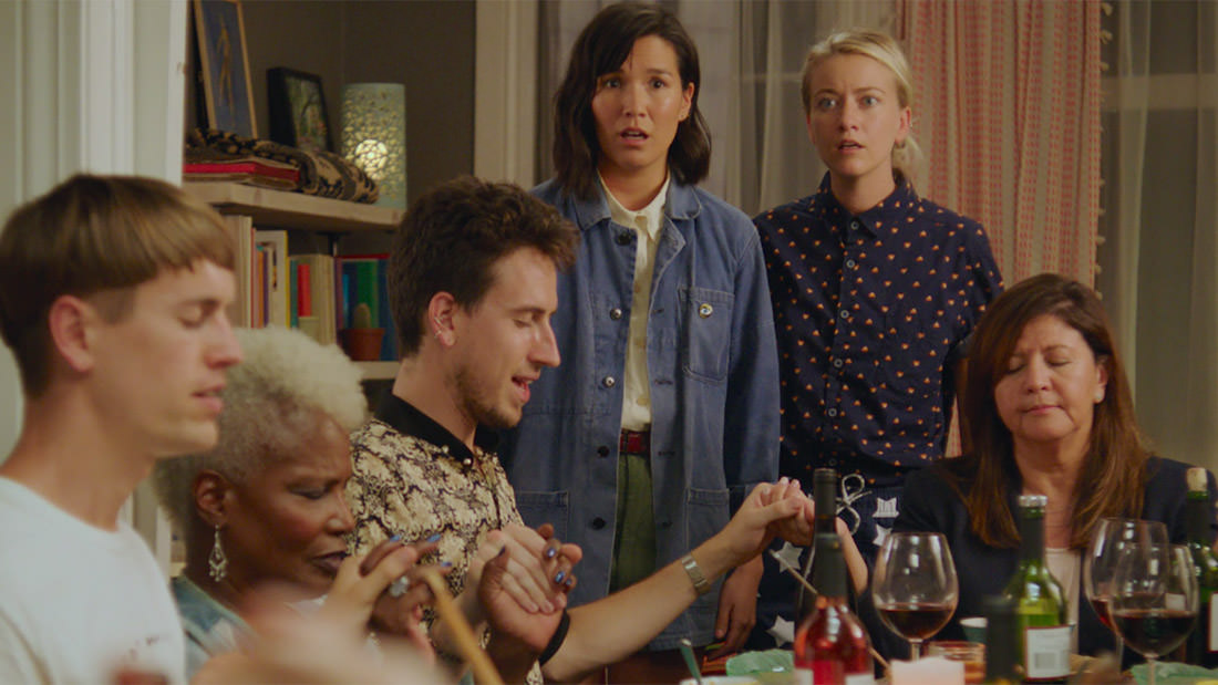 Four friends enjoying a cozy evening with laughter and drinks.