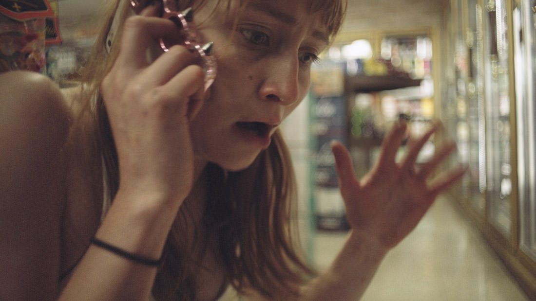 A shocked woman talking on the phone in a store.