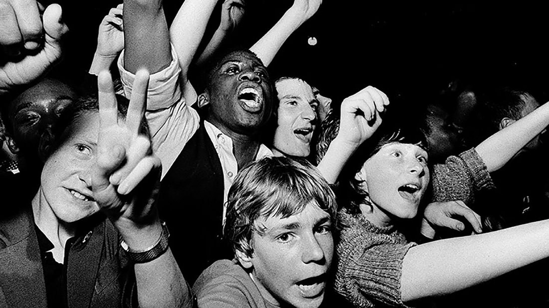 Excited crowd cheering energetically at an event.