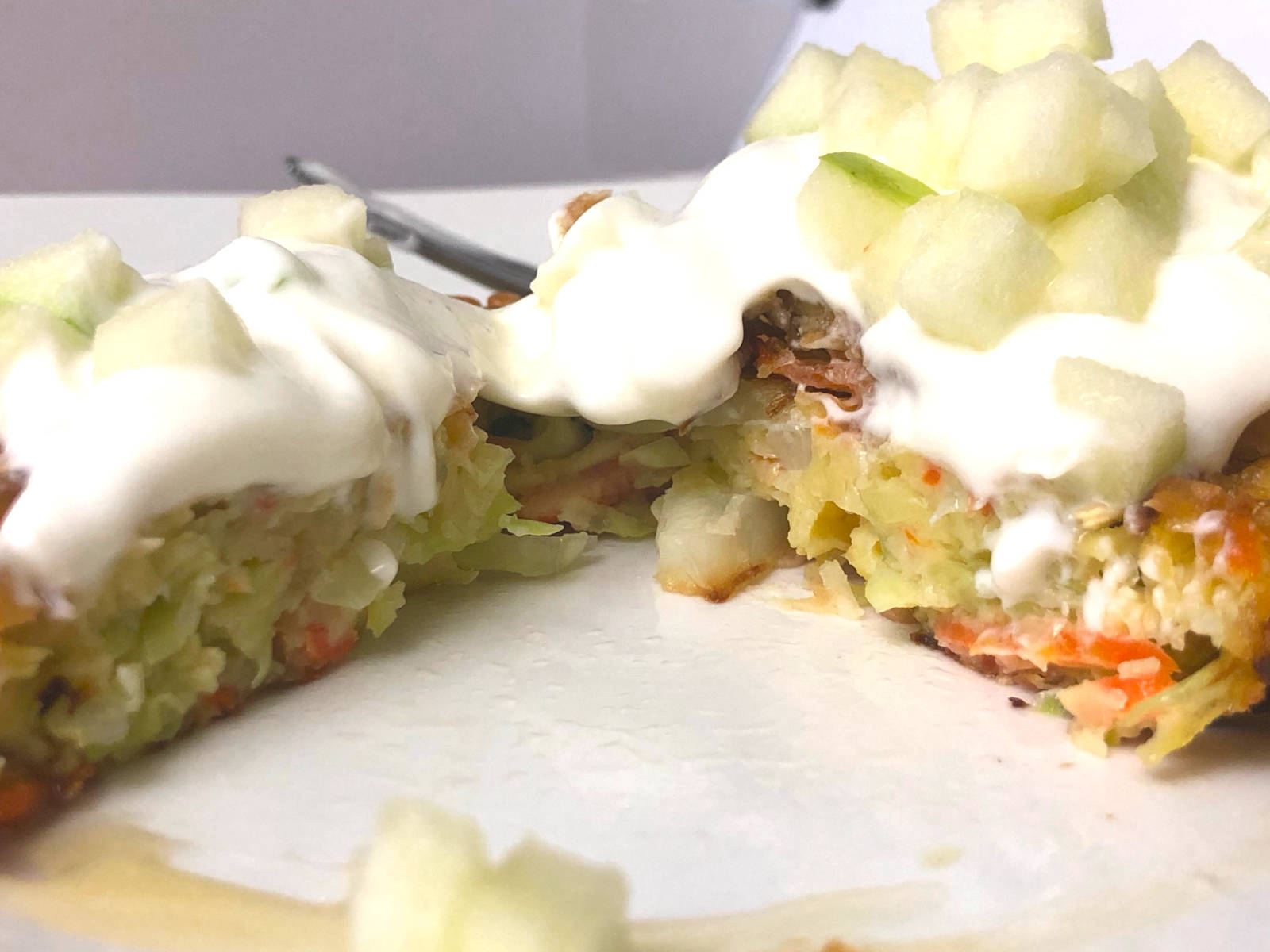 Side shot of vegetable cabbage fritter with honey greek yogurt and cubed green apple brunoise