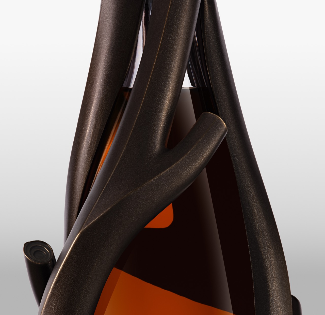 The Forge - Close-up of a dark brown sculpted bottle holder wrapping around a glass bottle filled with amber liquid, set against a light grey background.