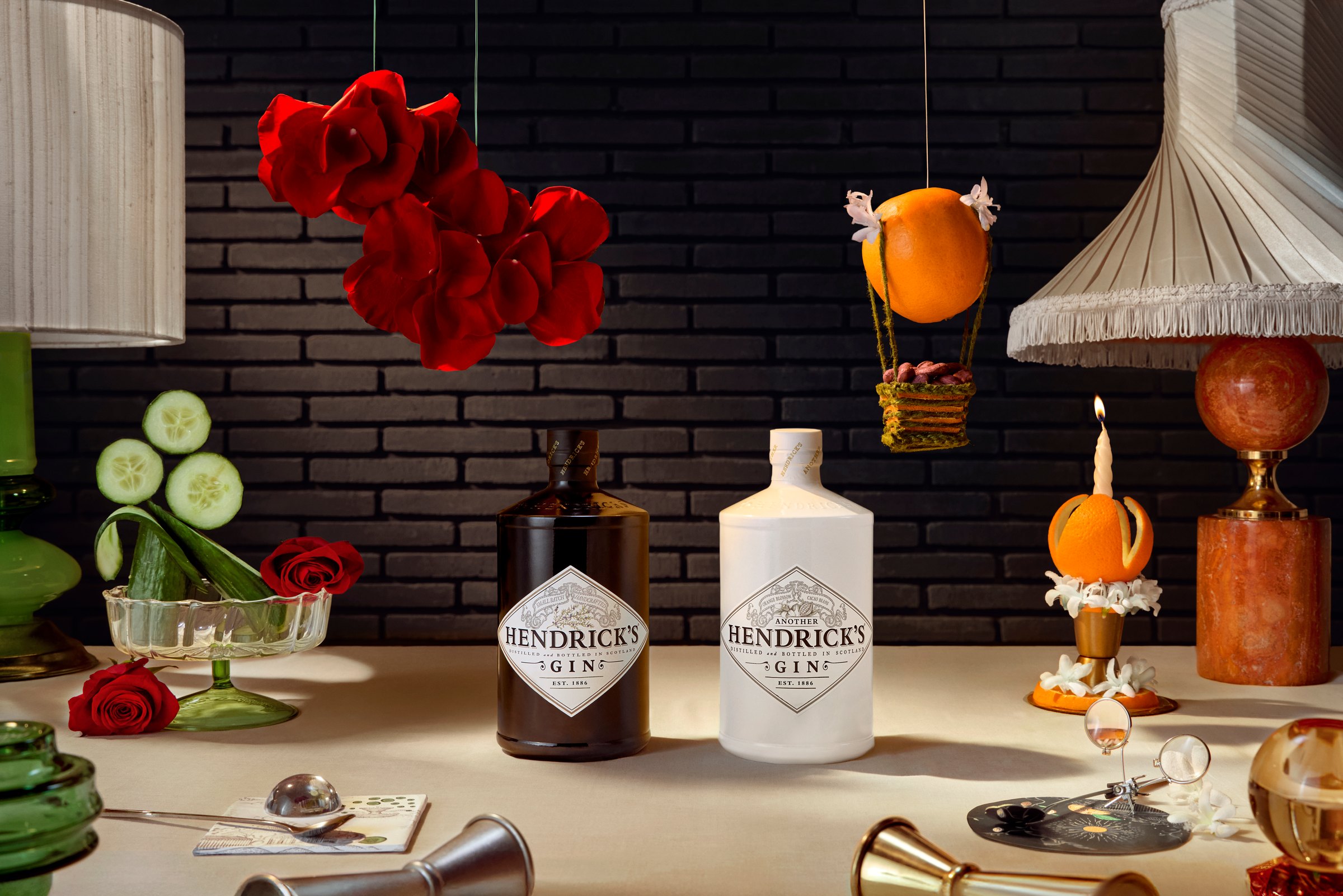 The Forge - Hendrick's Original and Another Hendrick's gin bottles on a set table beneath red roses and a hot air balloon.