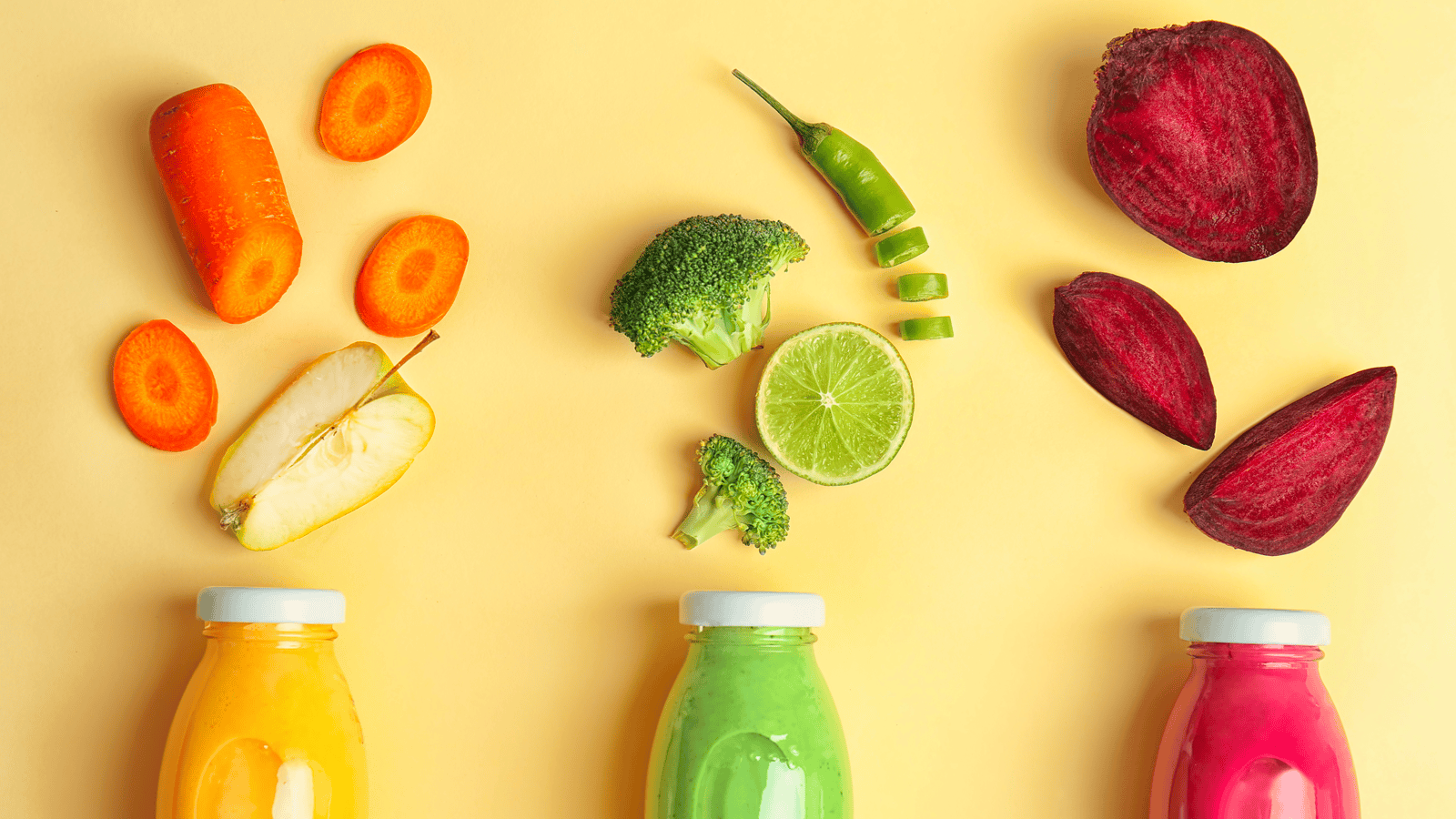orange, green, and pink fruits and vegetables above similarly colored bottles