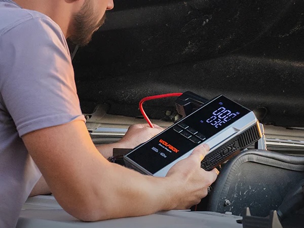 Jump starter with air compressor being used to inflate a car tire