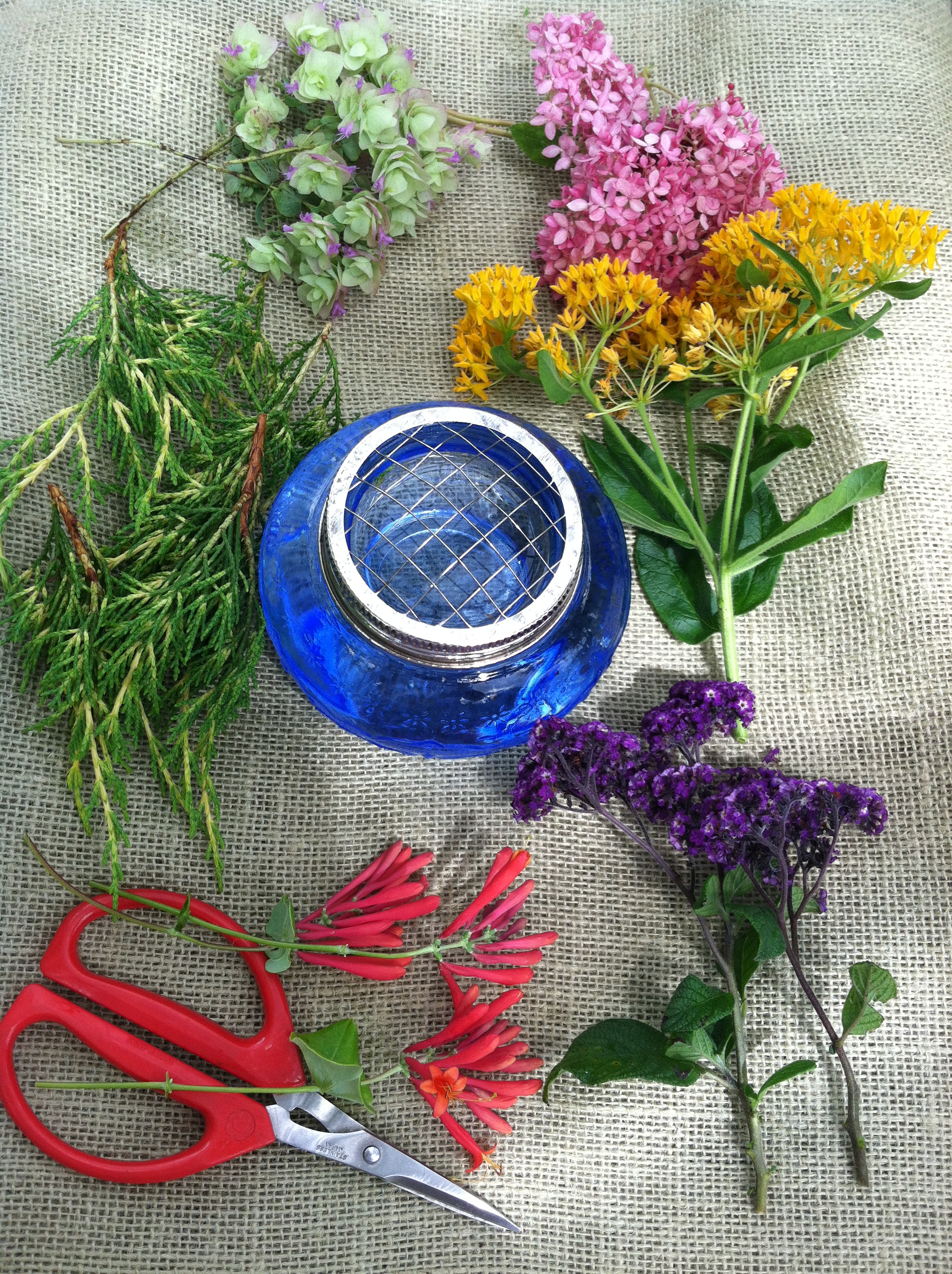 Set out your materials so you can see the colors together. The container has a wire topped divider to hold the flowers in place.