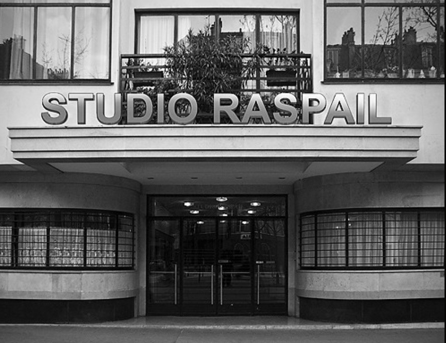 Entrée du Studio Raspail avec panneau en lettres éclairées.