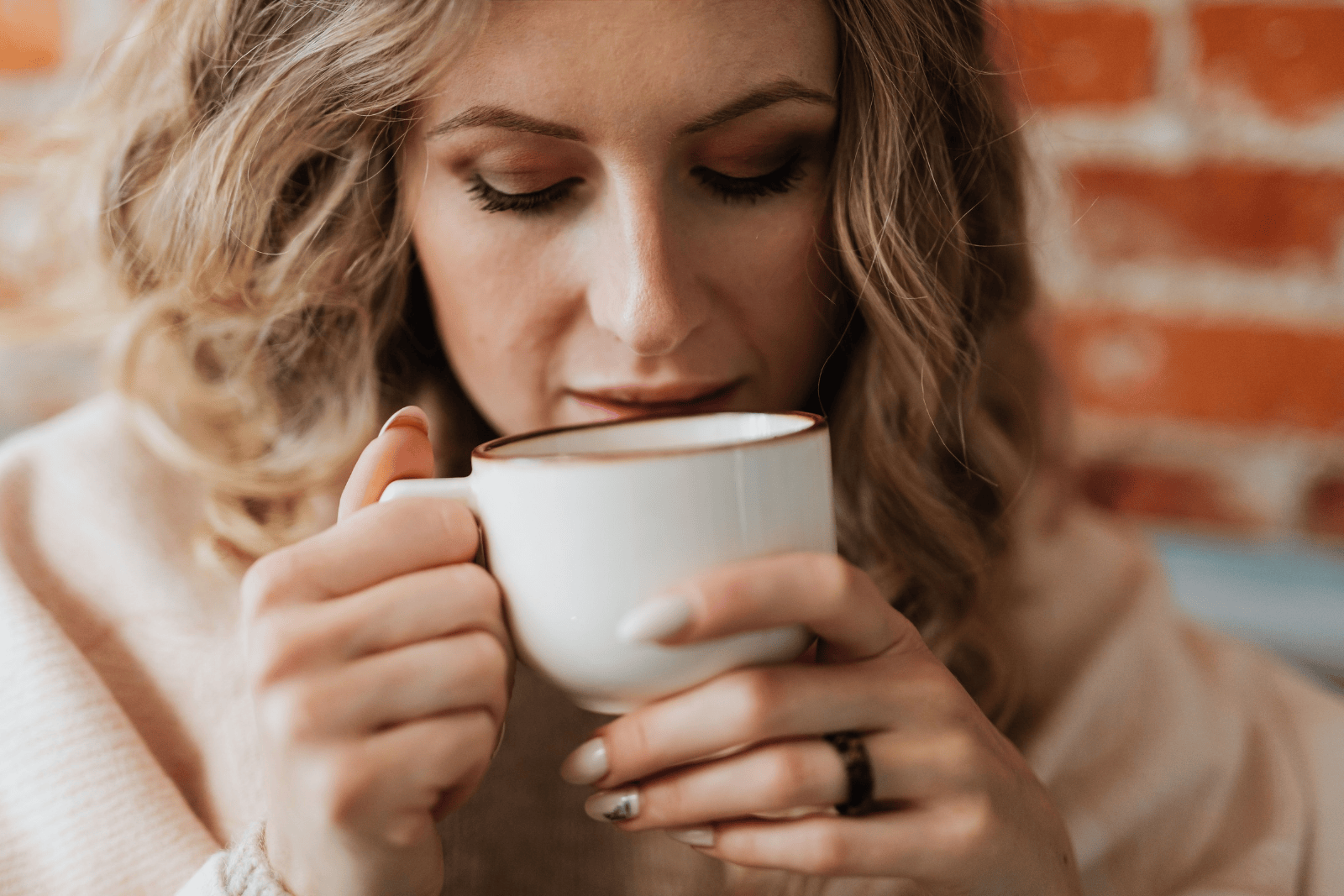 Woman sitting quietly at home with a cup of coffee, enjoying a slow weekend morning