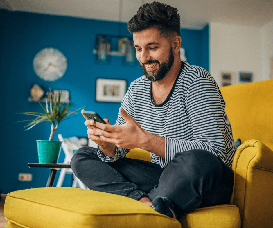 a-man-smiling-at-his-phone