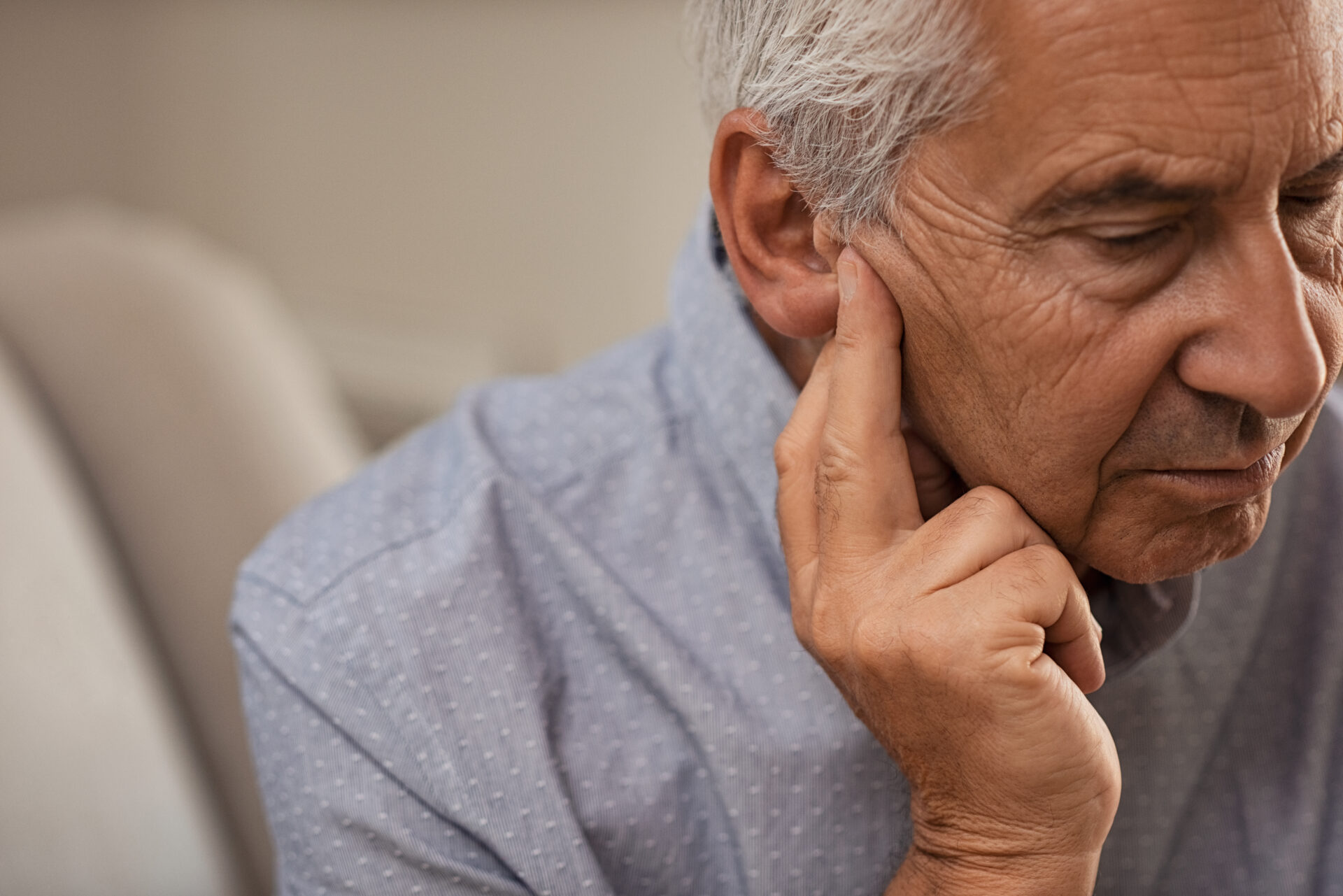 elderly man touching his ear