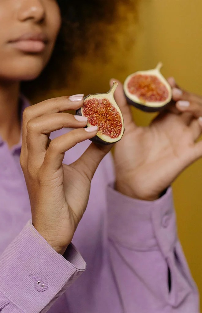 Photo of model grabbing a fruit.