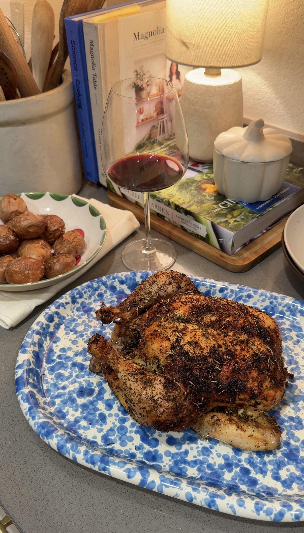roasted chicken on a serving platter with roasted potatoes