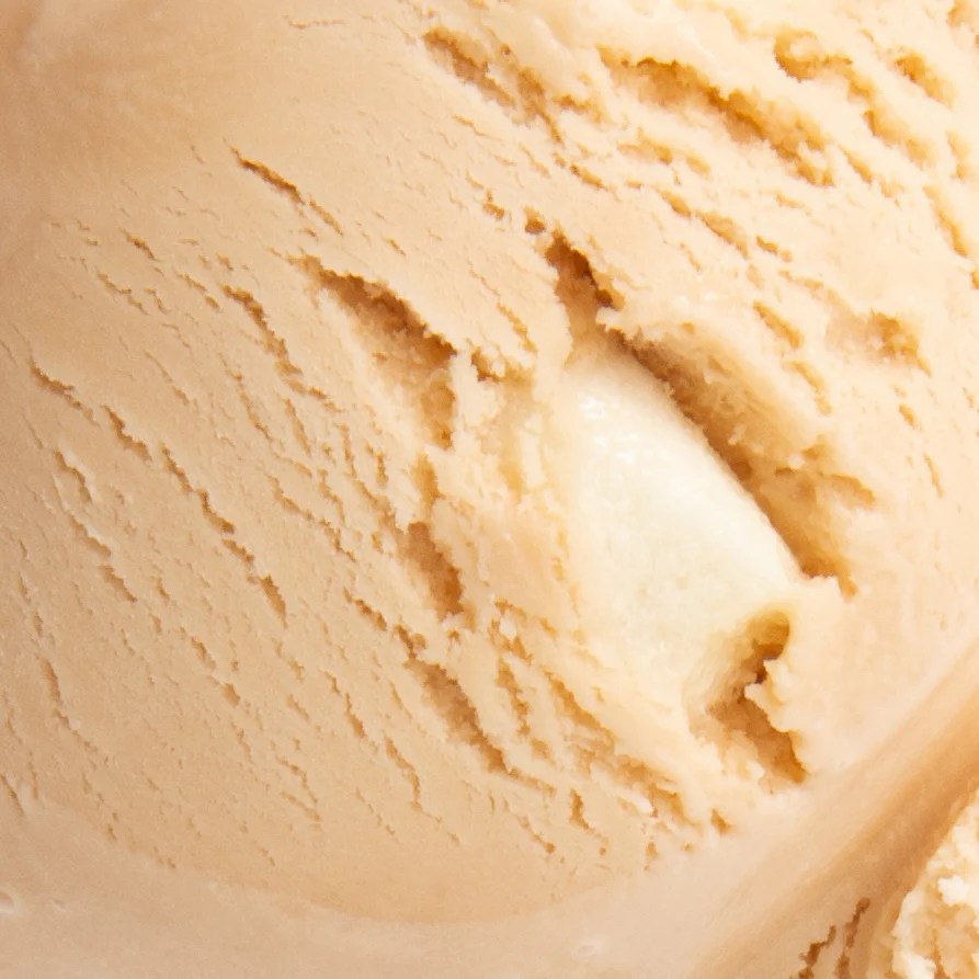 Close-up of creamy, light beige ice cream with a soft texture and smooth surface.