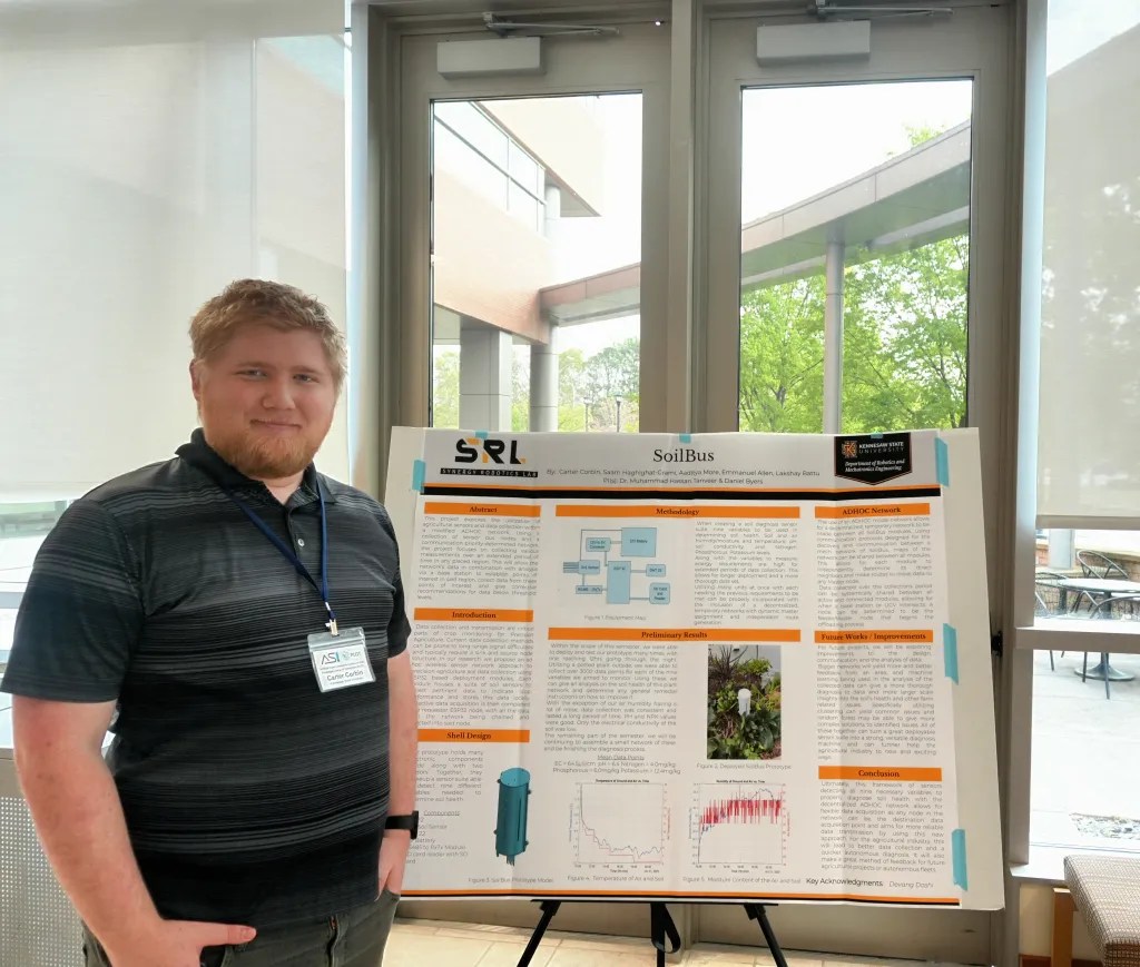 KSU master’s student Carter Corbin standing beside a poster displaying his team’s research at the PLOT Launch Event on April 1, 2026. Photo by Devyn Byers.