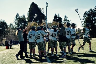 The Humboldt State Hogs Men's Lacrosse team holding up their sticks as they break away from a timeout. Men’s Lacrosse ended up losing 13-3 against Sierra Nevada College at Humboldt States College Creek events field on Saturday Feb. 25, 2017. | Juan Herrera