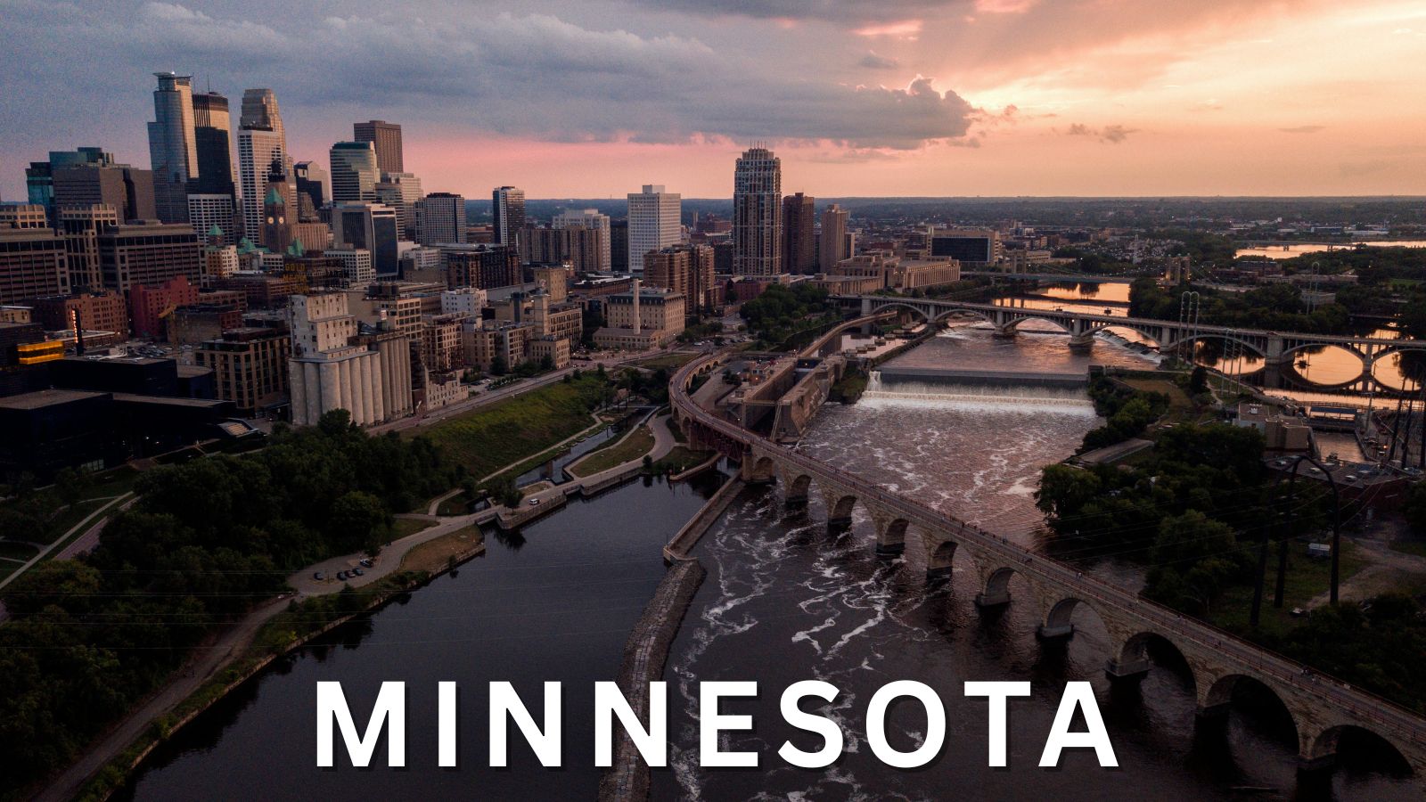 Minneapolis skyline at sunset with Stone Arch Bridge over the Mississippi River in Minnesota