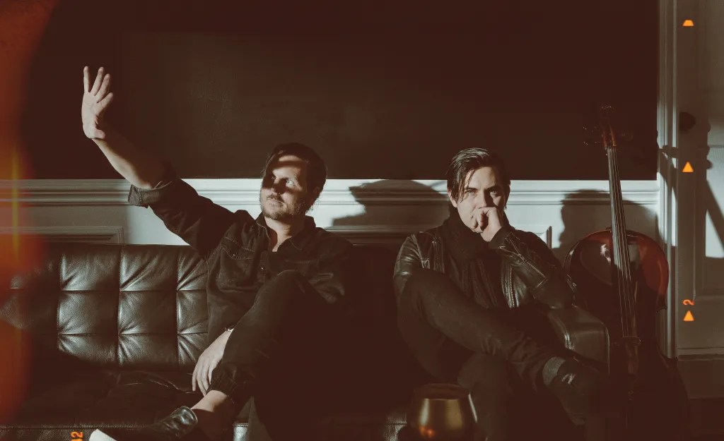 X-Men 97 composers The Newton Brothers sitting on a couch indoors.